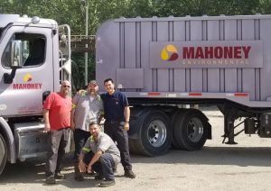 Ricardo with drivers in front of Mahoney truck Employee Spotlight